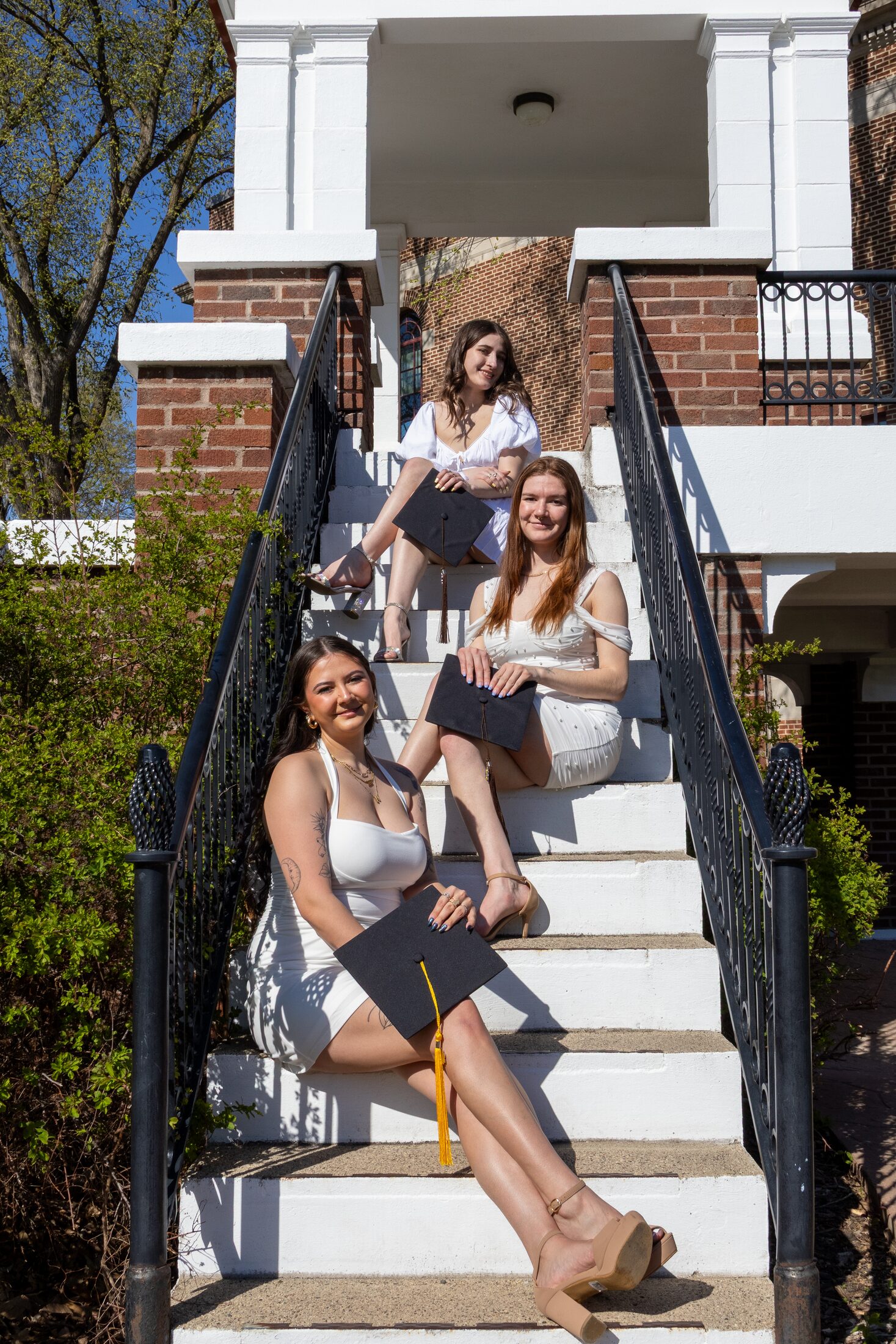 Friends celebrating graduation on outdoor steps